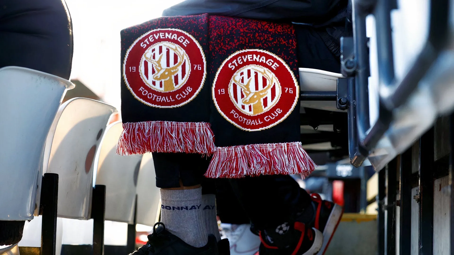 Cổ động viên Stevenage cổ vũ tại khán đài với khăn quàng